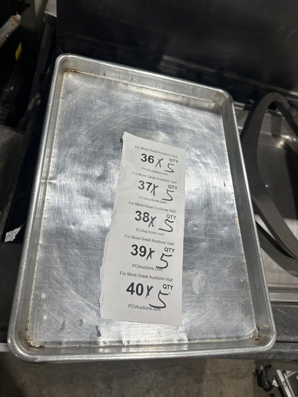 Commercial stainless steel baking sheet pan, lightly used. Includes auction tags with lot quantities. Durable and versatile.
