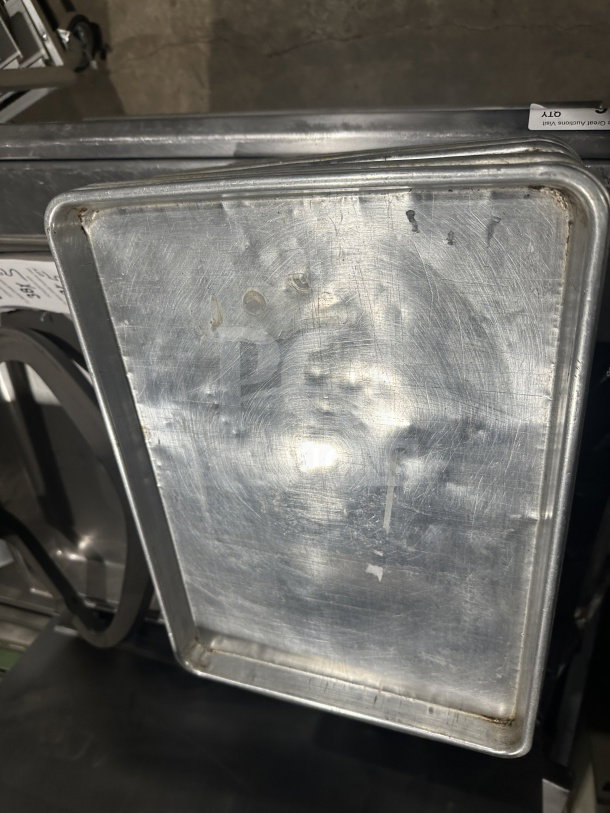 Commercial stainless steel baking sheet pan, durable and versatile. Used condition with visible wear.