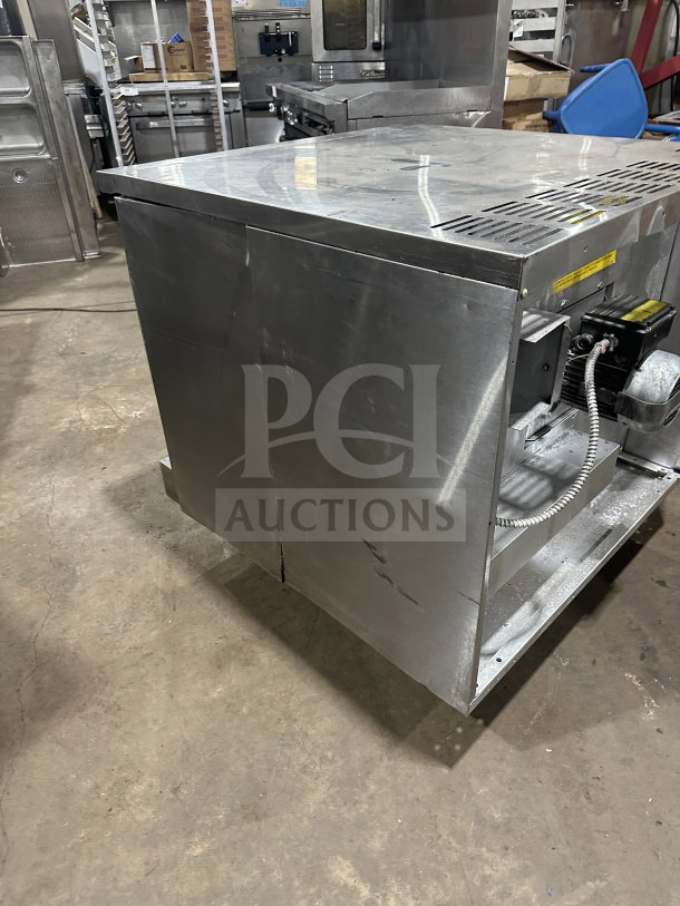 US Range stainless steel convection oven, gas-powered, includes simple controls and wired oven rack. Slight wear visible.