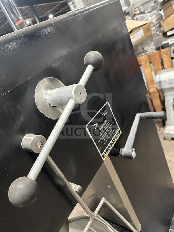 Blakeslee commercial black electric planetary mixer with stainless steel bowl guard and mixing bowl. Spiral hook attachment visible.