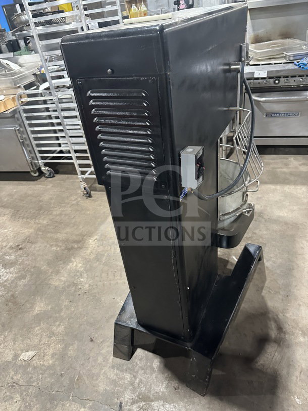Blakeslee commercial black electric planetary mixer with stainless steel bowl guard, mixing bowl, and spiral hook attachment on legs.