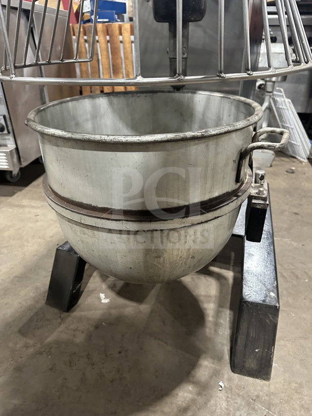 Blakeslee commercial black electric planetary mixer with stainless steel bowl guard, mixing bowl, and spiral hook attachment on legs.