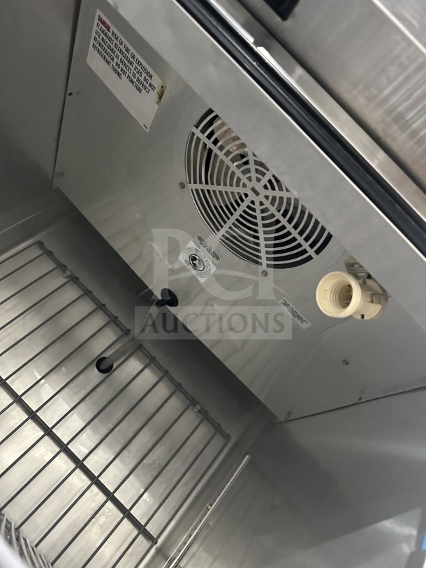 True T23FHC stainless steel single door freezer interior, showcasing poly-coated wire rack and fan, model and warning labels visible.