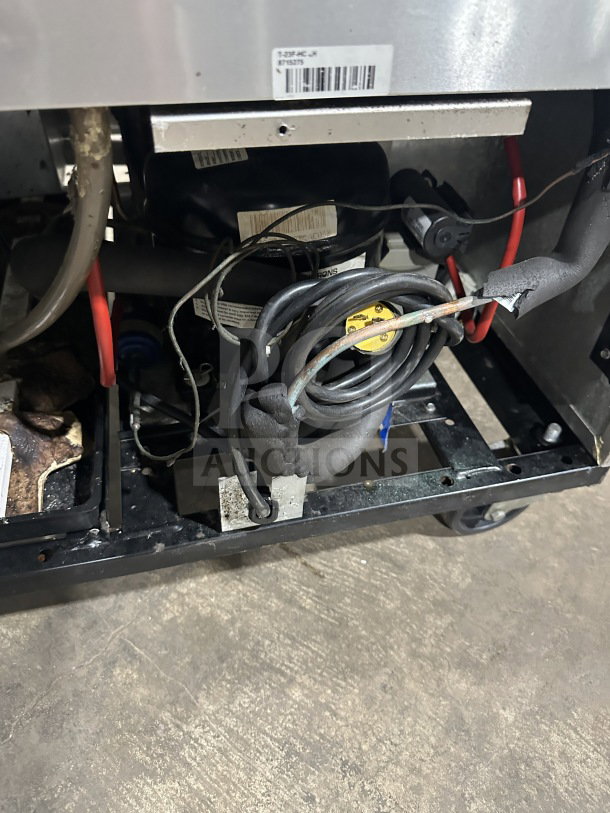 True T23FHC commercial freezer interior, showing wiring and components. Serial number 8715275 visible. Mounted on casters.