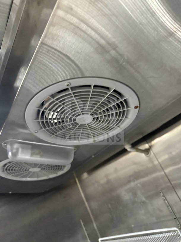 Migali T-Series C27 commercial stainless steel freezer interior with poly coated rack, fan, and light fixture.