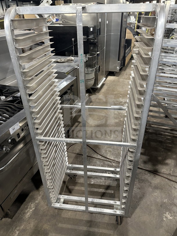 Commercial stainless steel heavy-duty sheet pan rack with multiple slots, on casters for mobility, excellent condition.