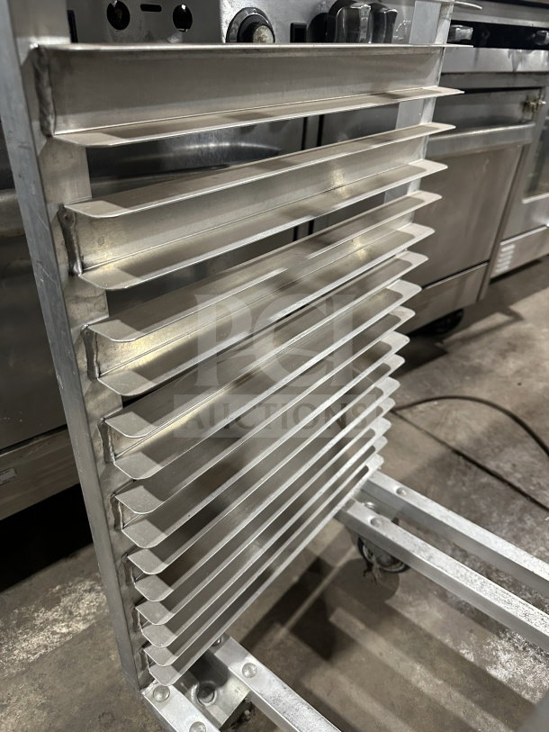 Commercial stainless steel heavy-duty sheet pan rack with multiple shelves, casters for mobility, in good condition.