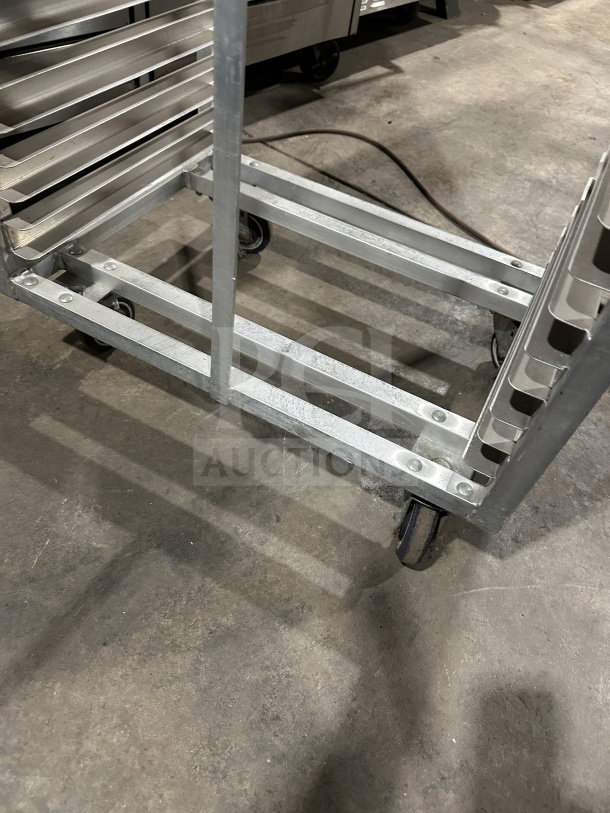 Commercial stainless steel heavy-duty sheet pan rack with casters, shown in industrial setting. Sturdy construction, excellent condition.