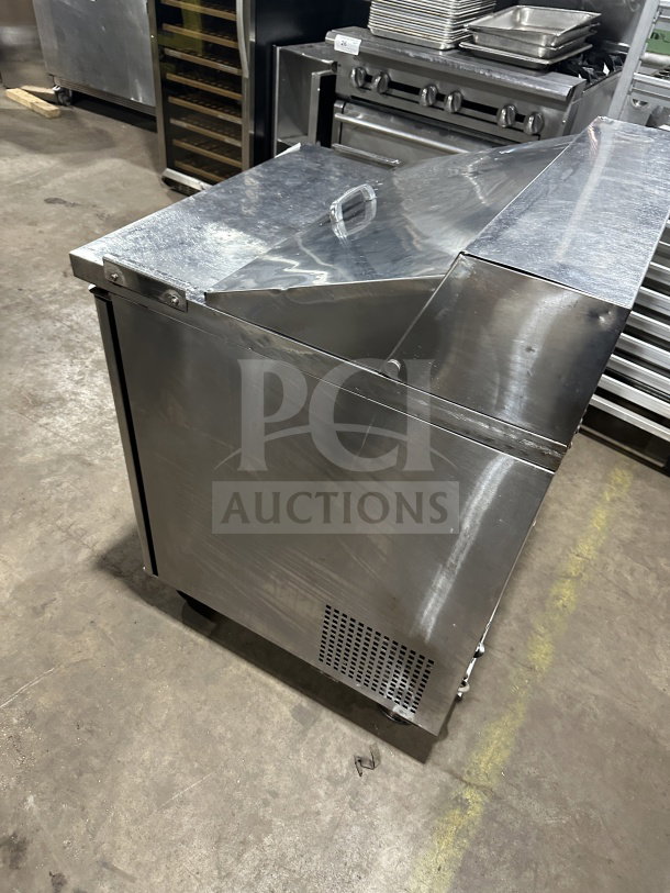 Turbo Air MST-28 refrigerated prep table with stainless steel finish, solid single door, and casters. Includes poly coated rack.