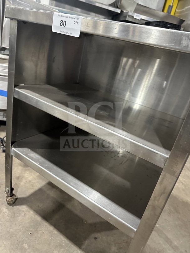Commercial stainless steel equipment stand with double undershelf, on casters. Durable construction, suitable for heavy use.