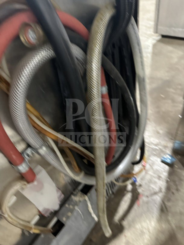 Champion UH130BM4 dishwasher; commercial-grade, stainless steel, high-temperature, undercounter model. Wires shown.