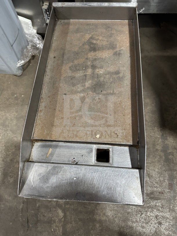 Commercial stainless steel gas countertop flat top griddle with legs. Shows signs of wear. Ideal for professional kitchens.
