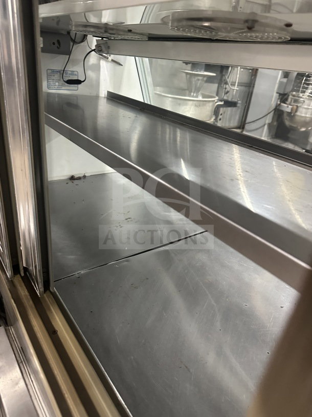 Leader stainless steel dual-service deli case with sliding rear glass doors and ambient top counter. Good condition.