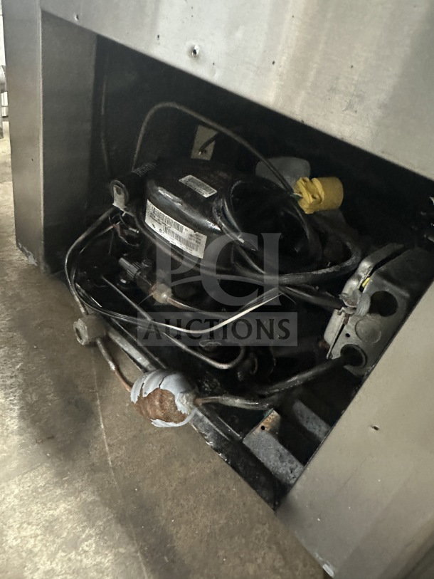 Leader stainless steel deli case refrigeration unit; visible wear and use. Dual-service glass door design with ambient top.
