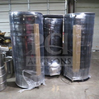 Three stainless steel vessels of a 253-gallon brew house with heat exchanger, wrapped and staged in a warehouse.