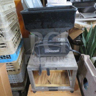 Brewtech SS 304 grain mill on casters. Features sturdy metal construction, hopper, and power cord. Good condition.