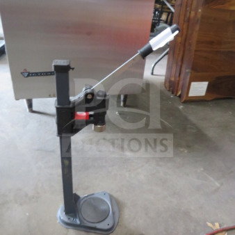 Manual bottle capper with metal base and handle, used condition. Ideal for homebrewing or small-scale bottling operations.