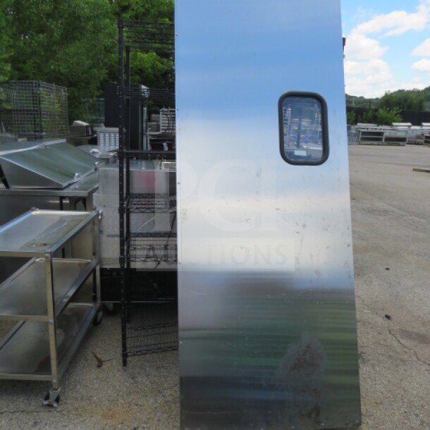 Stainless steel kitchen traffic door, 35.5x95 inches, with viewing window. Used condition with visible wear.