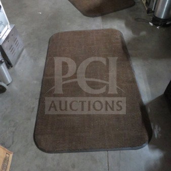 Brown 36x60 rug with rounded corners on concrete floor, showing a subtle checker pattern. Used condition.