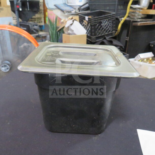 1/6 size food storage container, black, 6-inch deep with lid, used condition. Durable for kitchen or pantry use.
