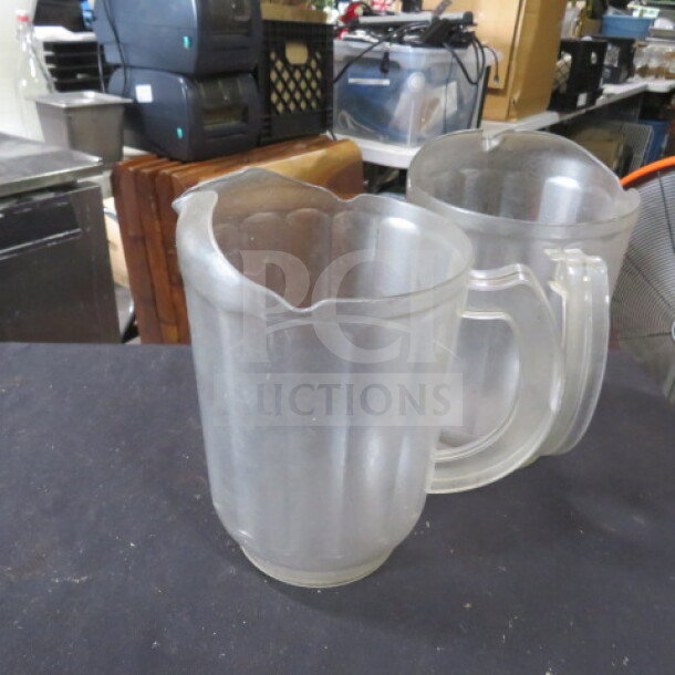 Clear poly pitcher, scalloped design, sturdy handle, good condition, suitable for beverages, restaurant or home use.