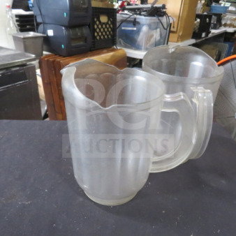 Clear poly pitcher, scalloped design, sturdy handle, good condition, suitable for beverages, restaurant or home use.