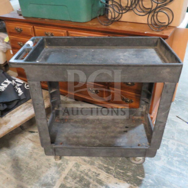 Black poly utility cart with 2 shelves on casters, measures 34x17.5x32.5 inches, slightly worn condition.