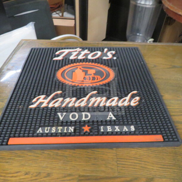Tito's Handmade Vodka bar mat, black with orange and white logo, text reads "Austin, Texas," in good condition.