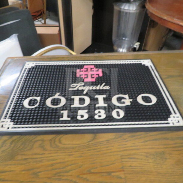 Black Código 1530 bar mat with pink logo and white text, used condition, measures approximately 24x14 inches, non-slip surface.