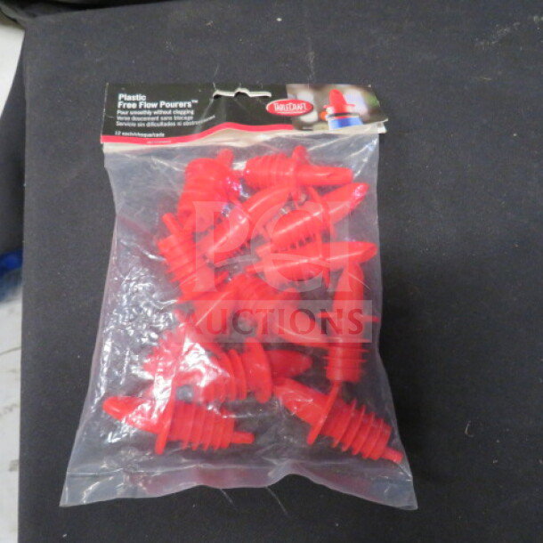 Bag of 12 new red free flow pourers, plastic material, in original packaging.