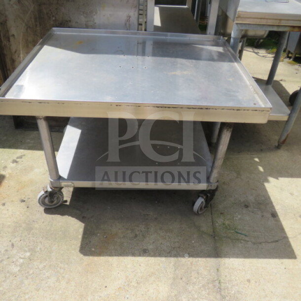 Advance Tabco stainless steel equipment table, 36x30x25 inches, features under shelf, casters; industrial-grade, used.