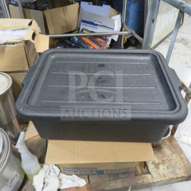Black bussing tub with lid, durable plastic, used condition. Suitable for storage or transport in kitchen or retail settings.