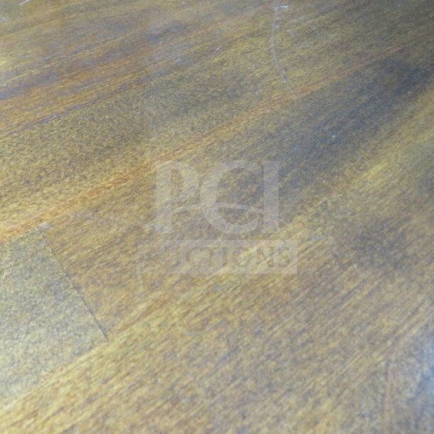 Wooden bar height table surface. Dimensions: 84x36x43 inches. Warm brown finish with visible grain and minor surface marks.