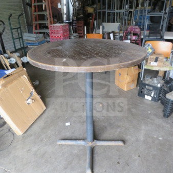 Round wooden table with pedestal base, measuring 36x30 inches. Natural finish, moderate wear visible. Ideal for auctions.