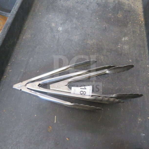 Stainless steel tong, 3XBID model, in good condition with auction tag number 18 visible.