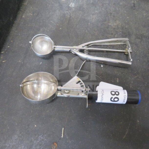 Two assorted dishers, metal construction, different sizes. One has a visible tag marked "89". Used condition.