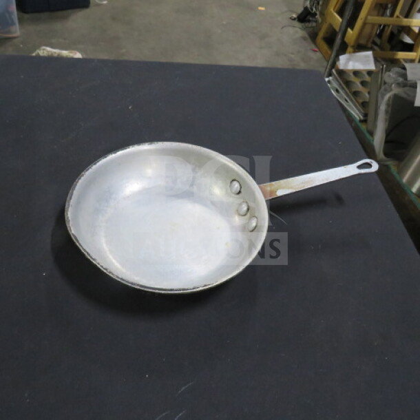 8 inch aluminum sauté pan, used condition, three rivets on handle, marked "2XBID," showing slight wear.