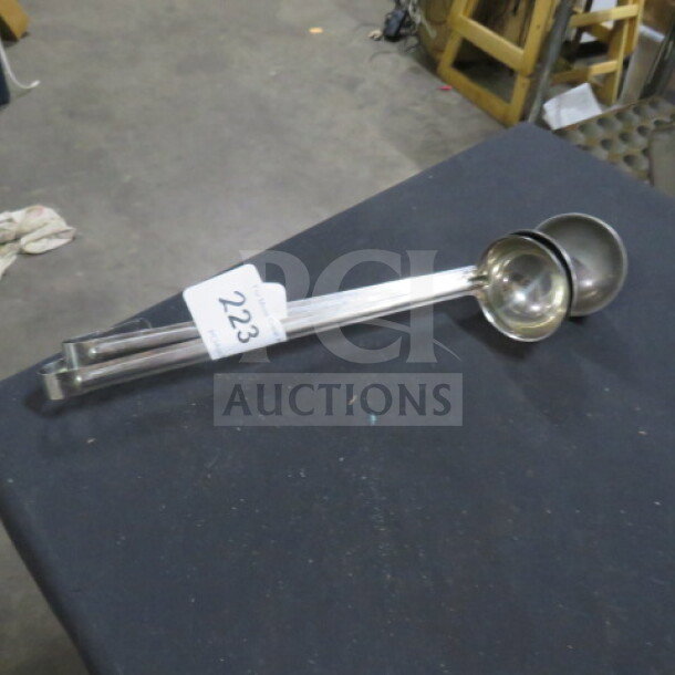 3oz stainless steel ladle, shiny finish. Includes auction tag labeled "223." Ideal for kitchen use.