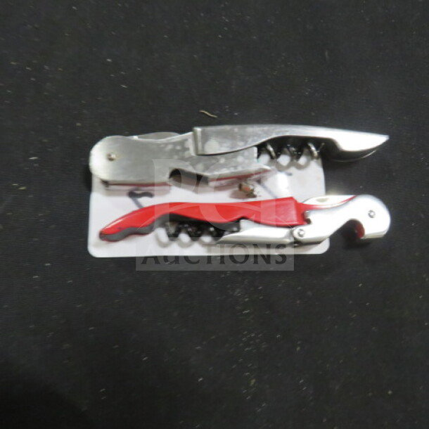 Two corkscrews on card; one silver, one red. Both in good condition, featuring bottle openers and foil cutters.