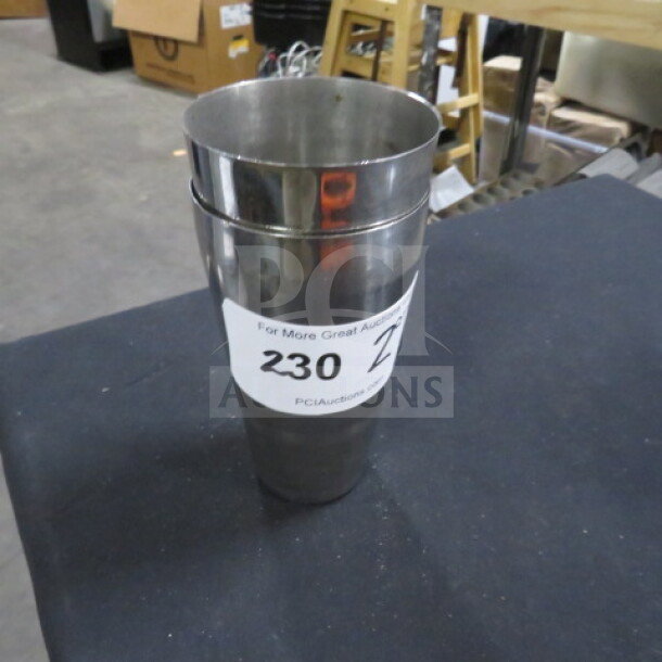 Stainless steel mixing glass with polished finish, in good condition. Auction tag reads "230 2XBID".
