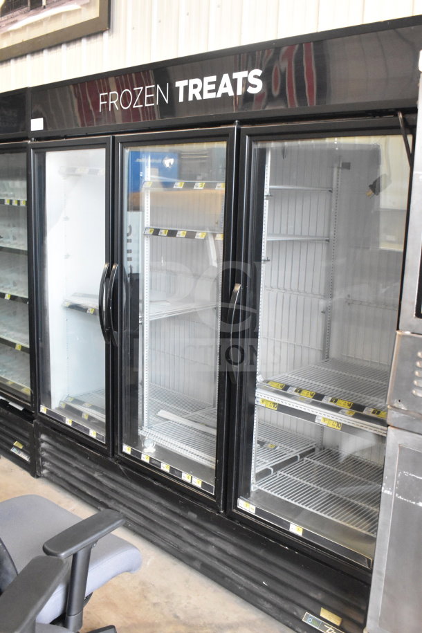 2017 True GDM-72F-HC 3-door commercial freezer. Black frame, glass doors, labeled "Frozen Treats." Tested and working.