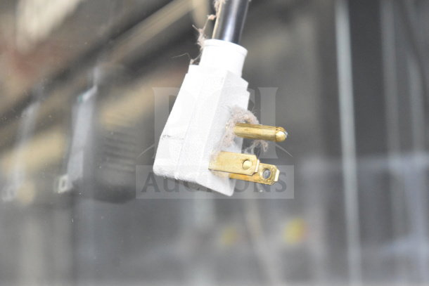 White power plug of the 2017 True GDM-49-HC cooler, showing brass prongs. Plug appears to be in functional condition.