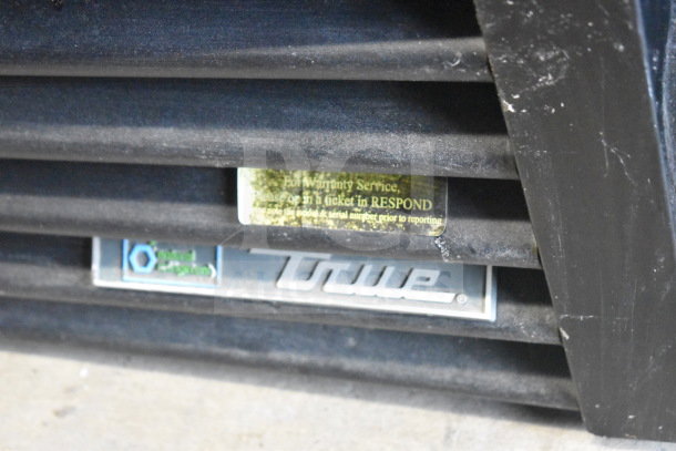2017 True GDM-72F-HC commercial freezer logo detail. Visible warranty tag and service instructions.