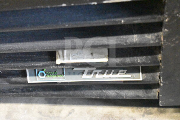 2017 True GDM-72-HC cooler logo and natural refrigerant label, showing front grill area, tested and working.