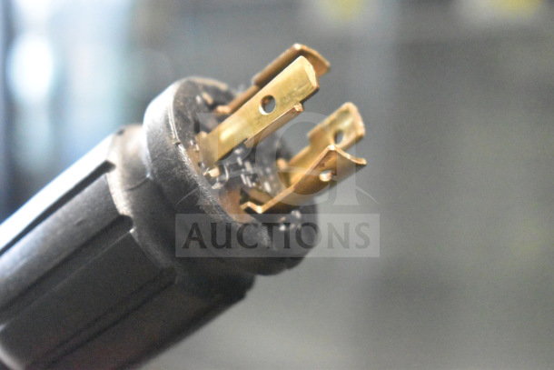 Close-up of plug for True GDM-72F-HC commercial 3 door reach-in freezer, showing brass prongs and black casing.