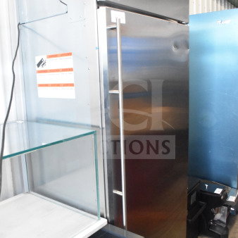 Stainless steel single door reach-in cooler with sleek design, sturdy handle, energy warning label, and good condition.