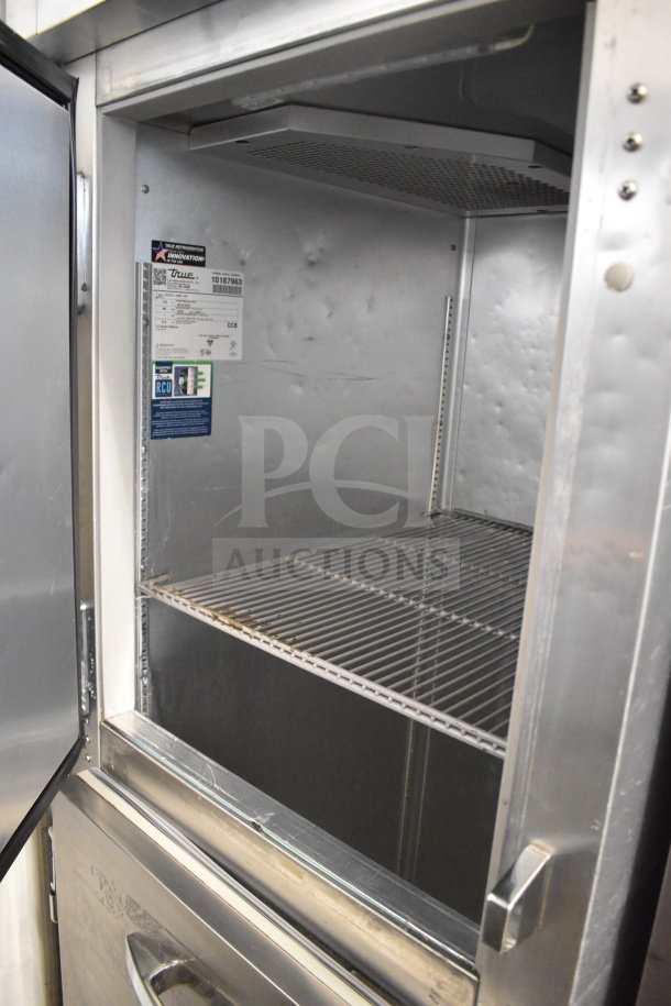 True STG1F-2HSLH-HC commercial cooler, two half-size doors, on casters, 115V, 1 phase. Interior label visible.