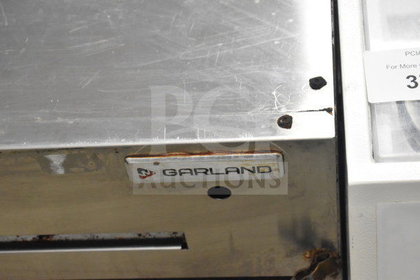 Garland Commercial Gas Cheese Melter with visible wear and rust, showing Garland logo. Ideal for professional kitchens.