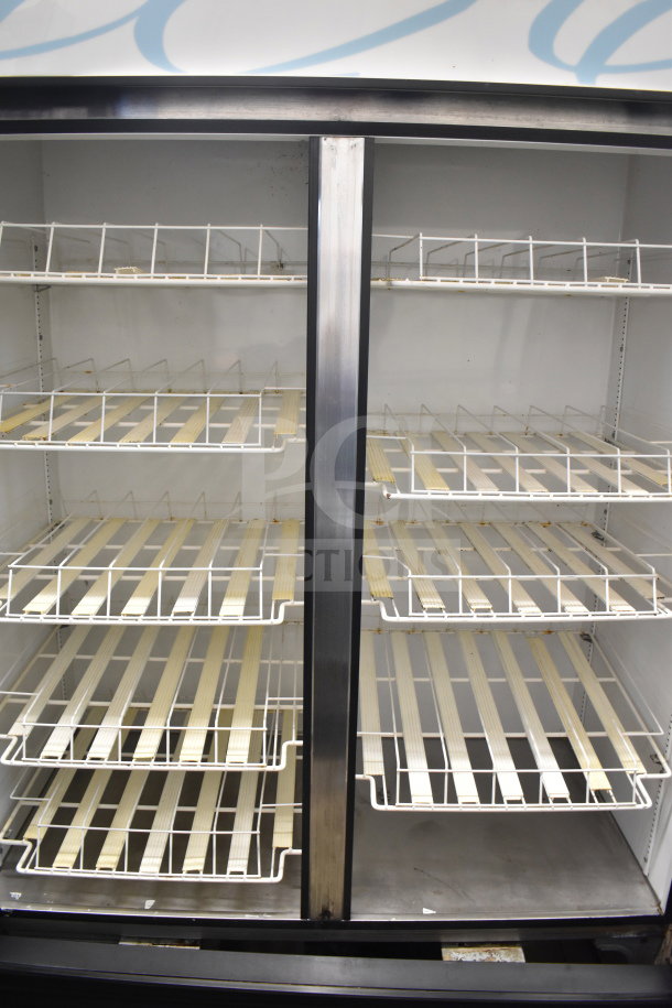 True GDM-49 commercial 2-door cooler merchandiser with glass doors and adjustable shelves. Appears in used condition.