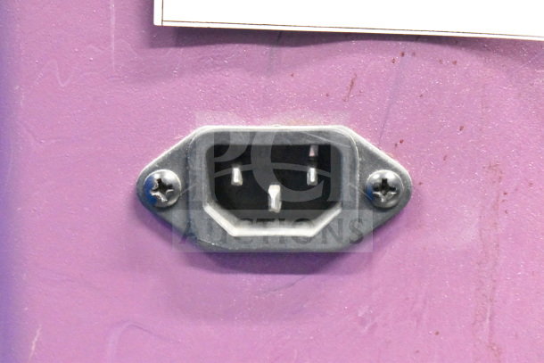 Power socket detail on purple countertop dry merchandising display case, showing connection point with visible screws.